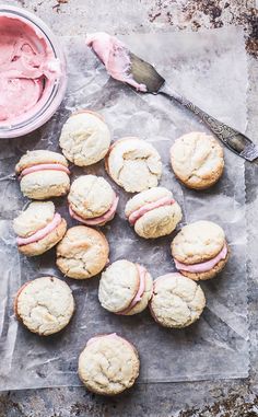 a table topped with muffins covered in pink frosting