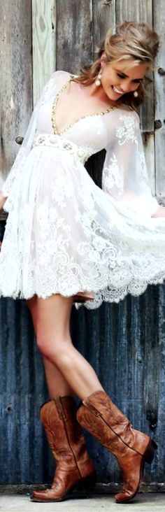 a woman in cowboy boots and a white dress posing for the camera with her hand on her hip