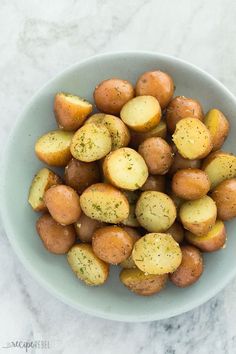 a white bowl filled with potatoes on top of a marble counter