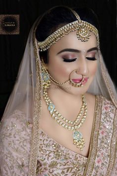 a woman in a bridal outfit with jewelry on her face and nose is looking at the camera