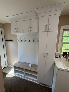 an empty room with white cabinets and drawers