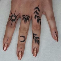 a woman's hand with tattoos on it and two fingers that have different designs