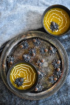 two bowls filled with yellow liquid on top of a metal tray next to each other