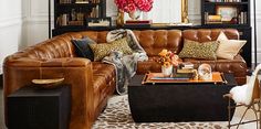 a living room filled with lots of furniture and bookshelves in front of a fire place