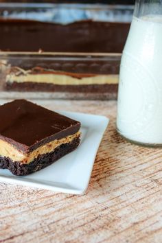 two pieces of cake on a plate next to a glass of milk