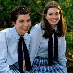 two girls in school uniforms posing for the camera