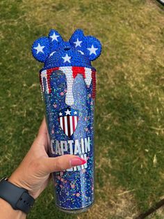 someone holding up a cup with the word captain on it and stars in the background