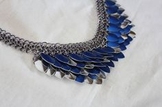 Sea Witch's Armor: This necklace/choker features a unique mix of standard scale mail weave and European 4 in 1. Woven with anodized aluminum scales and rings, this item is smooth and light weight. Necklace is fully edged to ensure stability and durability to the wearer. Dragon Scale Armor with a tinge of Mermaid inspiration for your alternative style Jewelry box. Connects with a lobster clasp and has extra length of chain making it fully adjustable to be one size fits most (12.5 to 15.5 inches). Sea Witch Costume, Armor Jewelry, Dragon Scale Necklace, Dragon Scale Armor, Scale Necklace, Scale Armor, Steampunk Festival, Scale Mail, Dragon Heart