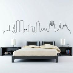 a bed sitting in a bedroom next to a wall mounted with a cityscape