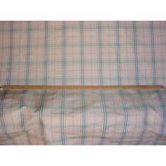 a bed with a wooden head board on it's side and plaid sheets in the background