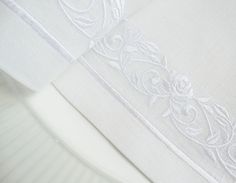 closeup of white fabric with decorative design on it's edges and bottom edge