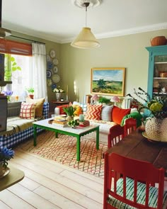 a living room filled with lots of furniture next to a wooden table and chairs in front of a window