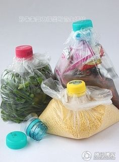 three plastic bags filled with different types of vegetables and fruits in them, sitting next to each other on a white surface