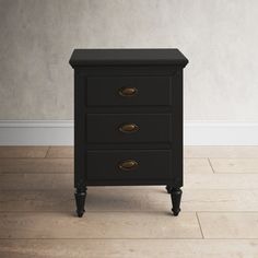 a black nightstand with three drawers on the bottom and one drawer in the middle, against a white wall