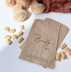 two brown bags sitting next to a teddy bear on top of a white tablecloth