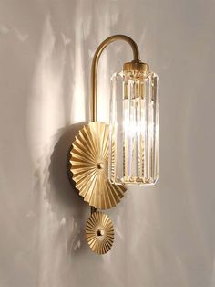 a wall mounted light with two lights attached to it's sides and a circular glass shade on the side