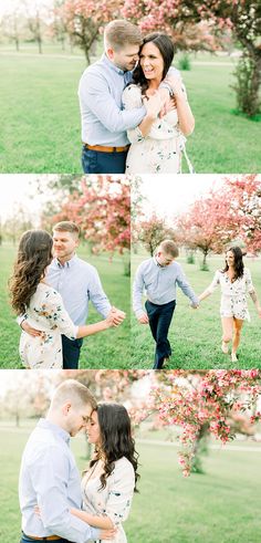 a man and woman holding each other while standing in front of trees with pink flowers