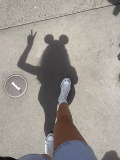 the shadow of a person standing in front of a frisbee on the ground