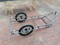 two bicycle trailers sitting on top of a brick sidewalk