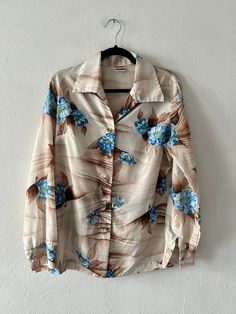 Vintage tan, brown and blue silky floral print pointed collar button up. Includes button sleeve cuffs. Unlined. DETAILSLabel: PykettesCondition: Excellent SIZE & MEASUREMENTSBest Fits: M/LLength: 31"Bust: 42"Waist: 38"Sleeve: 24"Shoulder: 16" Includes Free US Shipping Retro Long Sleeve Beach Tops, Retro Long Sleeve Beach Shirt, Retro Long Sleeve Shirt For Beach, Beach Retro Long Sleeve Blouse, Vintage Button-up Beach Top, Vintage Blouse With Collared Neckline, Vintage Long Sleeve Beach Shirt, Vintage Beach Tops With Button Closure, Vintage Long Sleeve Shirt For Beach