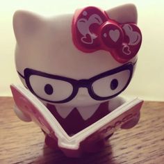 a hello kitty figurine reading a book