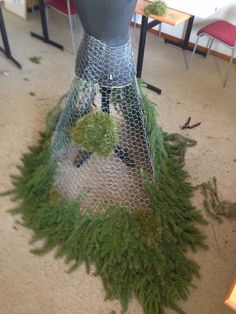 a chicken wire fence is covered with moss and other plants in a classroom room area