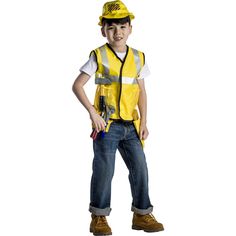 a young boy wearing a yellow construction worker's vest and hard hat, standing with his hands in his pockets