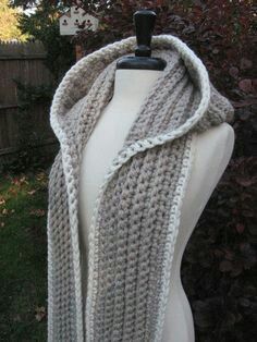 a white mannequin wearing a gray knitted scarf