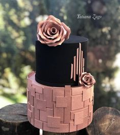 a three tiered cake decorated with flowers on top of wooden logs in front of trees