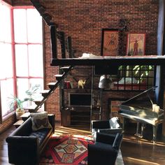 a living room filled with furniture next to a brick wall