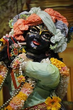 an elaborately decorated statue with flowers on it's head