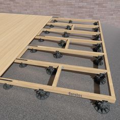 a wooden table with four wheels on it