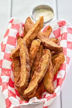 homemade potato wedges on a red and white checkered paper