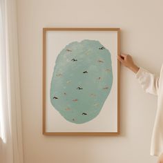 a woman standing next to a painting on the wall