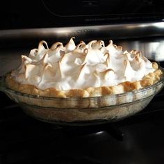 a pie sitting on top of a stove covered in meringue