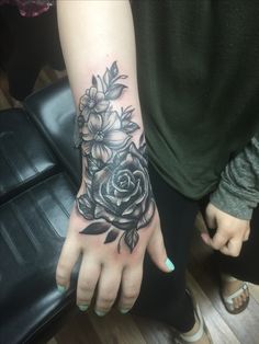 a woman's hand with flowers on it