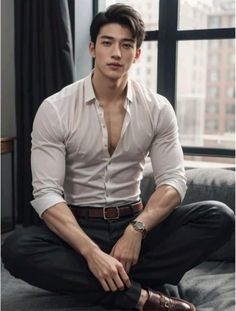 a young man sitting on top of a couch wearing a white shirt and black pants