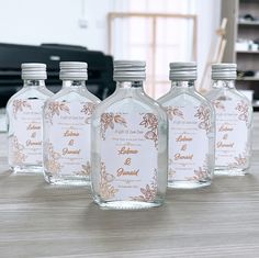 four bottles are sitting on a table in front of a computer