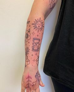 a woman's arm with tattoos on it and a clock in the middle of her hand