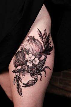 a woman's thigh with flowers and leaves on her leg, in black and white