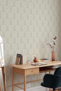 a desk and chair in front of a wallpapered room with an art deco pattern