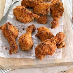 fried chicken on a cutting board with a knife and fork