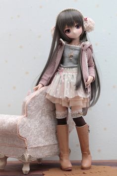 a doll is standing next to a chair