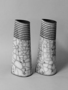 two black and white vases sitting next to each other