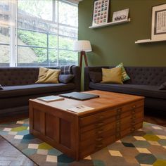 a living room with two couches and a coffee table in front of a window