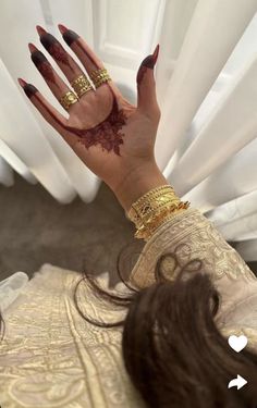 a woman's hand with hendix and gold rings on her left arm