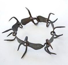 a bracelet made out of metal scissors on a white surface