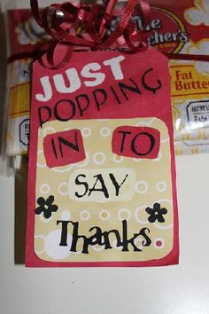 some candy bags with tags on them that say, just popping in to say thanks