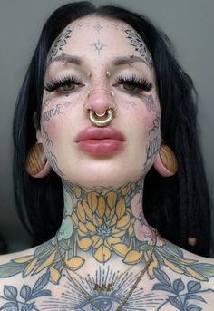 a woman with tattoos and piercings on her chest