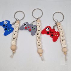 three wooden key chains with video game controllers on them, one is for kids and the other is for adults